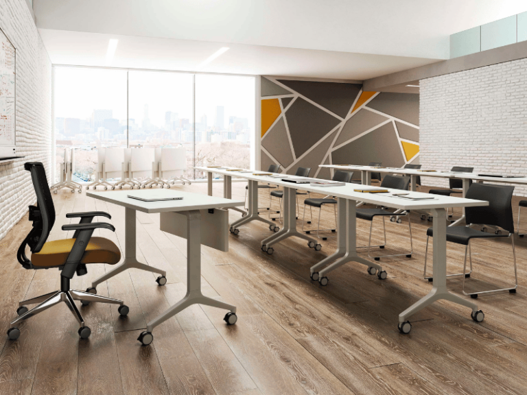 Classroom featuring white flip-top tables on casters with black chairs.