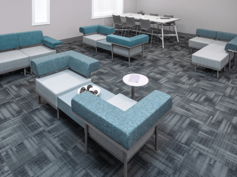 Lounge area with a multi-height modular seating pieces in a variety of blue patterned fabrics.