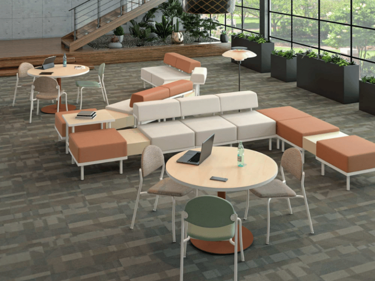 Lounge area featuring a large modular seating piece and two round tables with chairs.