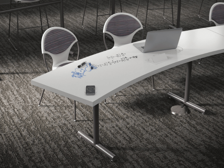 A curved desk with a white marker board top and two round back chairs.