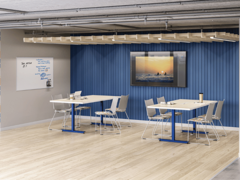 Two tables in an education environment with white tops and blue metal frames that have four chairs each.