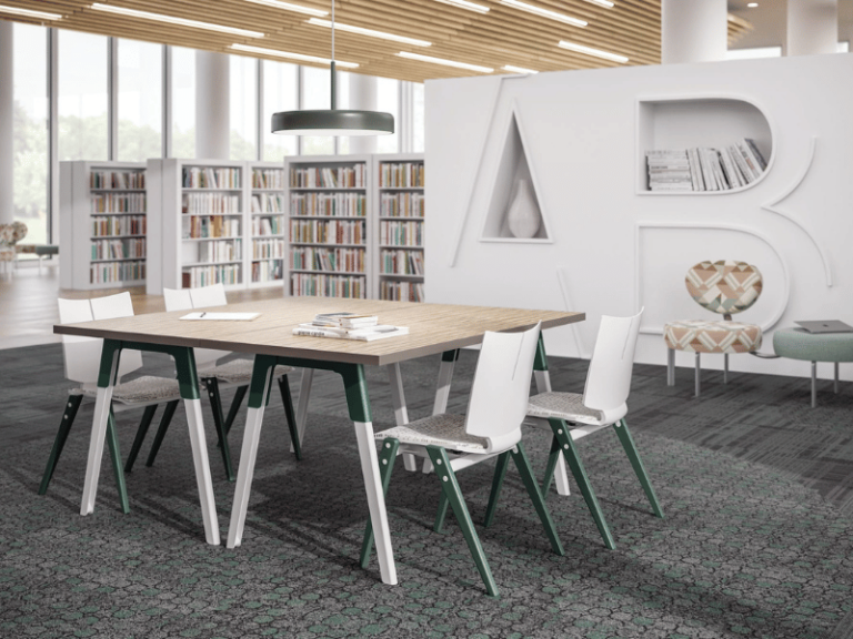 Table and four chairs featuring a white and green frame in a library lounge area.