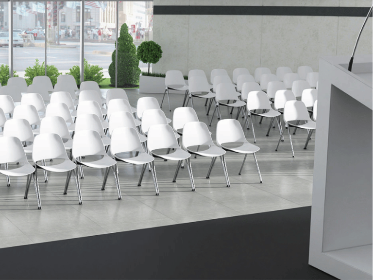 Lecture hall with white chairs facing a lectern.