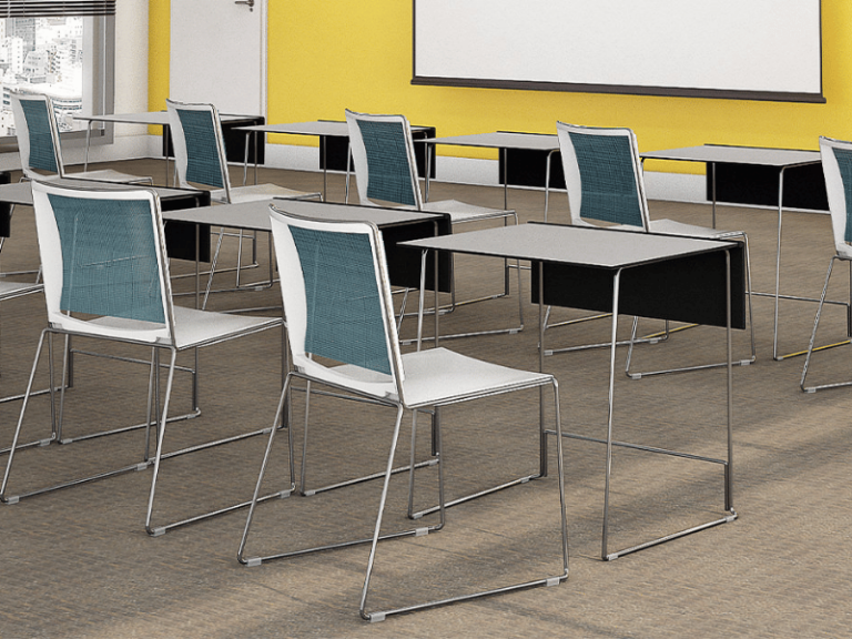 An education classroom features multiple desks and chairs in front of a projector screen.